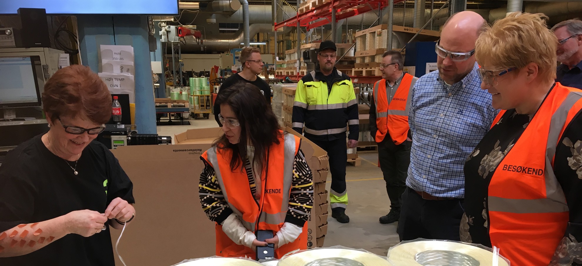 Mangfolds - og likestillingsminister Trine Skei Grande (V) følger interessert med når operatør Sidsel Holter (t.v) viser frem glassfibertrådene som produseres på 3B Fibreglass.
